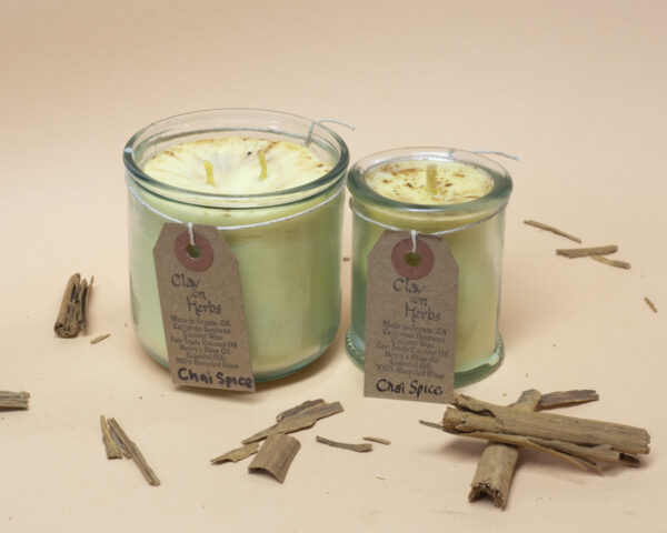 large and small Chai Spice candles witha light brown backdrop and cinnamon bark scattered